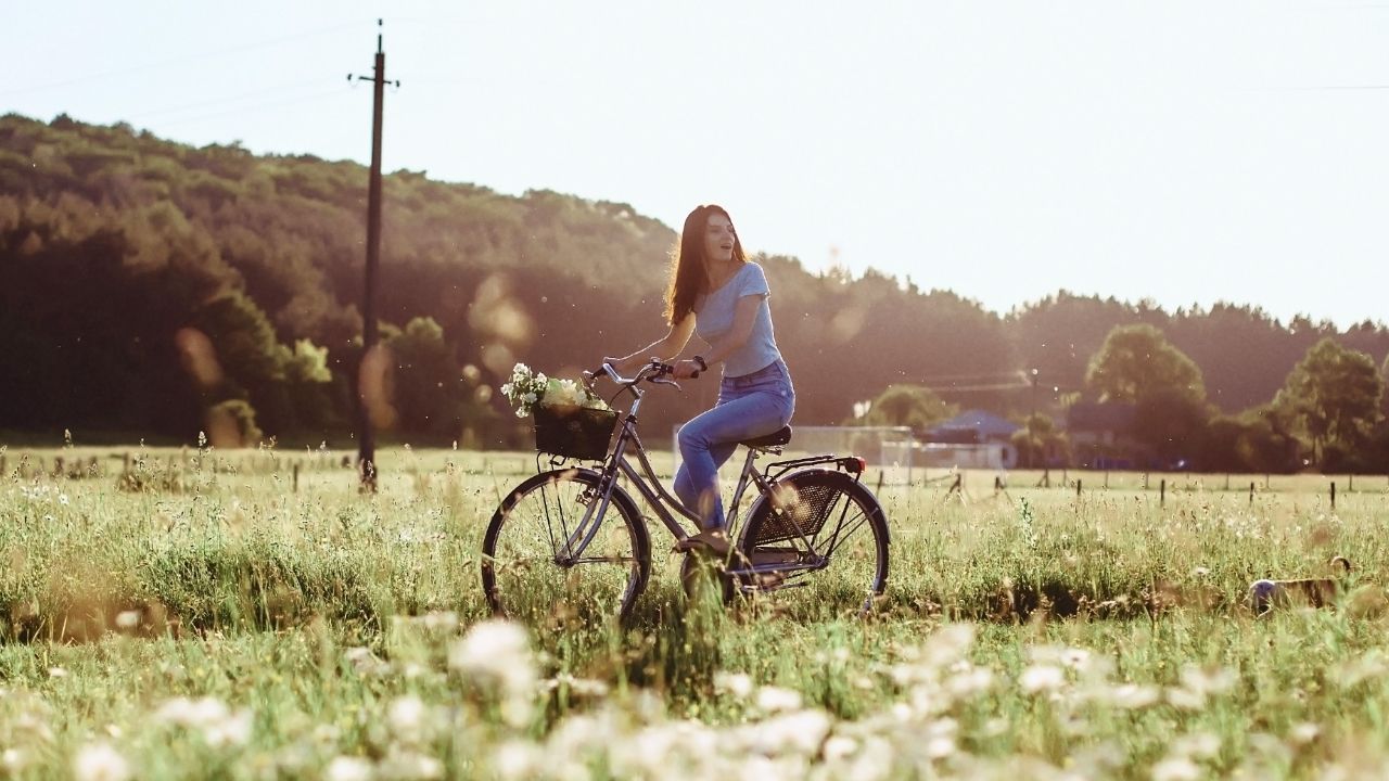 girl-walks-with-puppy-field-bicycle-back-sunny-light